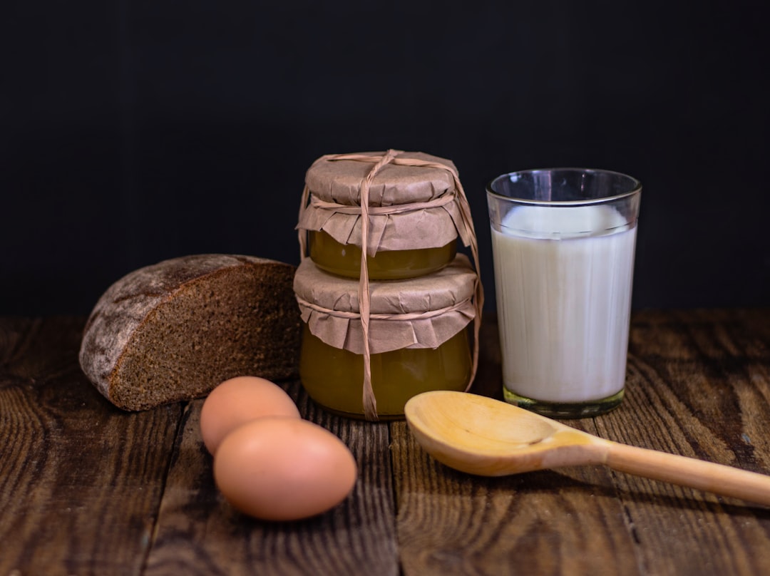 a wooden table topped with bread and a glass of milk