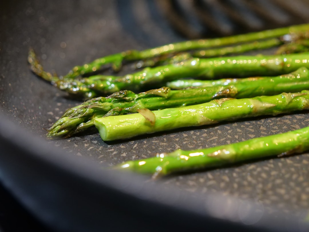 Green asparagus spears cooking in a pan